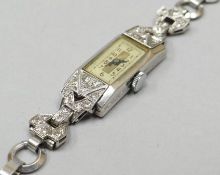 An Art Deco platinum encased ladies cocktail watch decorated with diamonds, the movement marked