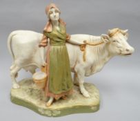 A Royal Dux model of a standing milkmaid with cow on a naturalistic base and coloured in the typical