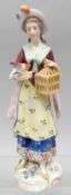 A small Chelsea porcelain figure of a standing lady wearing decorative costume with bird and bird-