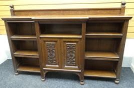 A large open Arts & Crafts stained oak break-front bookcase with adjustable shelves either side of