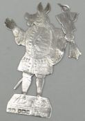 A novelty silver heraldic tablet or pendant in the form of a standing medieval-costumed