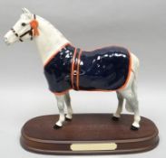 A Royal Doulton horse sculpture 'Welsh Mountain Pony' wearing blue blanket and rosette, on a