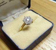 An 18kt yellow gold ring with a floral cluster of seven diamonds, cluster 1.1 cms diam