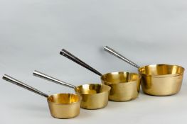 Four 19th Century graduated brass pans with polished iron handles
