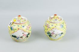 A pair of yellow ground jars and covers with panels of a child at play with his mother, the other
