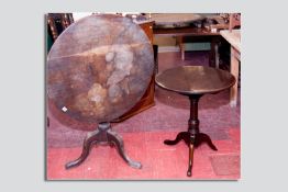 An antique mahogany tilt top tripod table having a circular top on two bearers with block mount