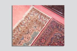 A light coloured woollen patterned carpet, 96 x 144 ins (244 x 366 cms) and a red ground woollen rug