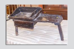 An 18th Century and later oak and pine stool, the rustic made piece with sectional tray top and