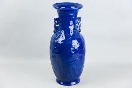 A large, possibly Oriental, cobalt blue vase, relief moulded with phoenix birds and stars with