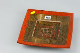 A double dished square stoneware bowl with mottled iron red and brown high fired glaze decoration