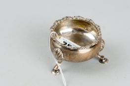 A circular silver salt pot with three shell and hoof supports and crimped style rim, 2.4 ozs, London