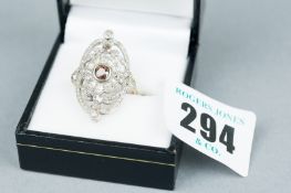 An oval diamond encrusted lady's dress ring having a centre round cut amber stone with twelve