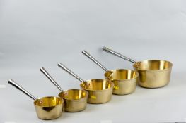 A set of five Victorian graduated brass saucepans with polished iron handles