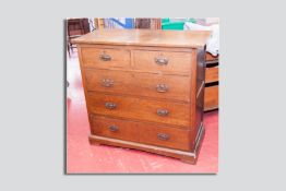 A late Victorian/early Edwardian oak chest of two over three drawers with copperized repousse back
