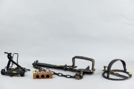 A group of three brass and iron animal traps and a wooden three hole spring mousetrap, various