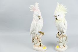 A pair of Royal Dux porcelain models of cockatoo standing on a branch amongst foliage, one with pink