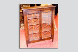 An oak leaded twin glazed door bookcase, 46 x 36 ins (117 x 91.5 cms)