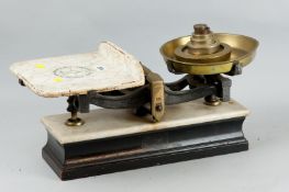 A set of cast iron and brass shop scales by Parnall & Sons, Bristol on a white marble and ebonized