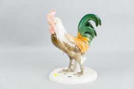 A Nymphenburg porcelain model of a standing cockerel, the proud bird with full tail plumage and pink