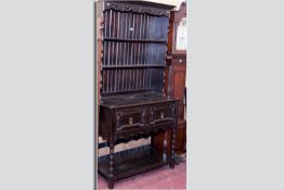 A dark oak Jacobean style dresser, shaped pierced frieze over a panel backed and shaped fronted