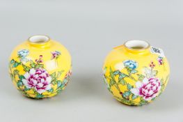 A pair of yellow ground bulbous vases, hand decorated with floral sprays and gilt decorated rims,