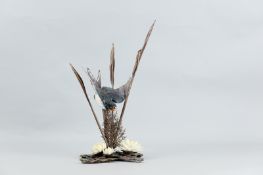 An Albany Fine China bronze and porcelain model of a Swallow swooping between bronze fern and floral