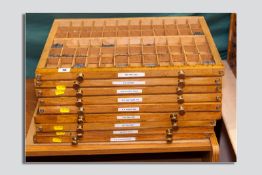 Nine brass handled sectional trays containing a large quantity of lead type in various founts