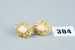 A pair of eighteen carat gold bark effect oval earrings, each set with a cabouchon shell coral, 20