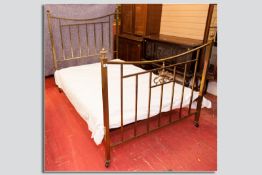 A Victorian brass and iron bedstead, box shaped brass work bedends with decorative end panel and urn