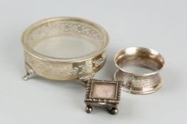 A silver napkin ring of waisted form and a small square lidded silver stamp box on four ball feet