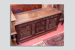 An 18th Century and later carved oak dower chest, a replaced plank moulded top over a carved