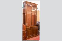 An Edwardian mahogany bookcase with double glass door top and panelled cabinet doors below, an