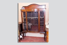 An Edwardian mahogany and leaded glass display cabinet with shaped railback top, inlaid with