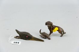 A cold painted bronze figure of a gun dog with its quarry and a well modelled bird's head letter