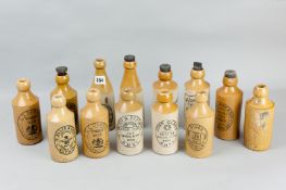 Thirteen stoneware ginger beer etc bottles with various brewers stamps including local, 8 ins (20.25