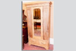 An Edwardian pine mirrored single door wardrobe with drawer below, 78.5 x 44 ins (199.5 x 112 cms)