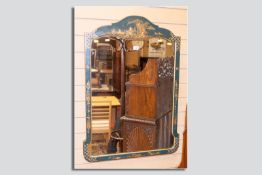 An early 20th Century blue chinoiserie decorated wall mirror having a shaped top with gilt relief