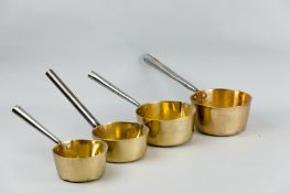 Four brass and polished iron handled saucepans of various sizes, three with lip