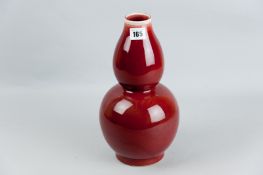 An ox blood double gourd vase, 12 ins (30.5 cms) high, impressed character mark to the base (later