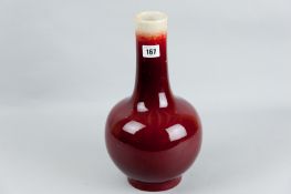 A Sang de Beouf slender neck bottle vase, 13 ins (33 cms) high (damaged and repaired to collar and
