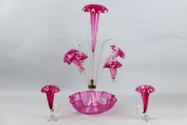 A Victorian cranberry epergne with trailed glass decorations and a pair of similar cranberry glass