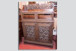 An excellent profusely carved rosewood bookcase cabinet having twin carved glazed doors to the top