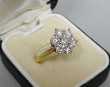 An 18kt yellow gold ring with a floral cluster of seven diamonds, cluster 1.1 cms diam