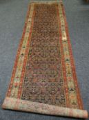An early twentieth century intricately patterned wool-pile runner-carpet bearing Waring & Gillow
