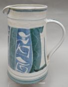 An Aldermaston studio-pottery jug of tapering form and with loop handle decorated in aqua and blue