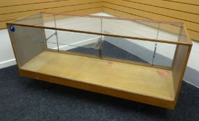 A late twentieth century light wood and glass retailer's counter display raised on a metal base with