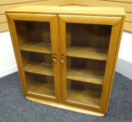 A modern lightwood Ercol glazed bookcase on a curved plinth base, 36 ins x 39 ins (92 x 100 cms)