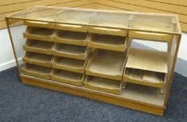 A late twentieth century light wood and glass retailer's counter display on a plinth base,