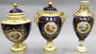 A cream and blue ground Coalport gilded trio with painted countryside scenes by E O Bell, comprising