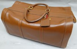 A late twentieth century brown leather holdall by Dunhill with locking outer zip and zipped interior